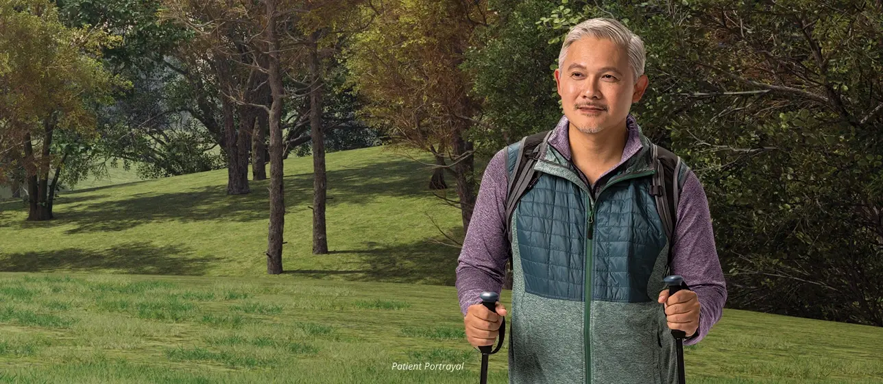 Man with backpack outdoors (patient portrayal)